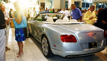 Invited guests look at the Bentley convertible